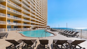Un espace piscine d’hôtel avec des chaises longues et une vue sur l’océan.