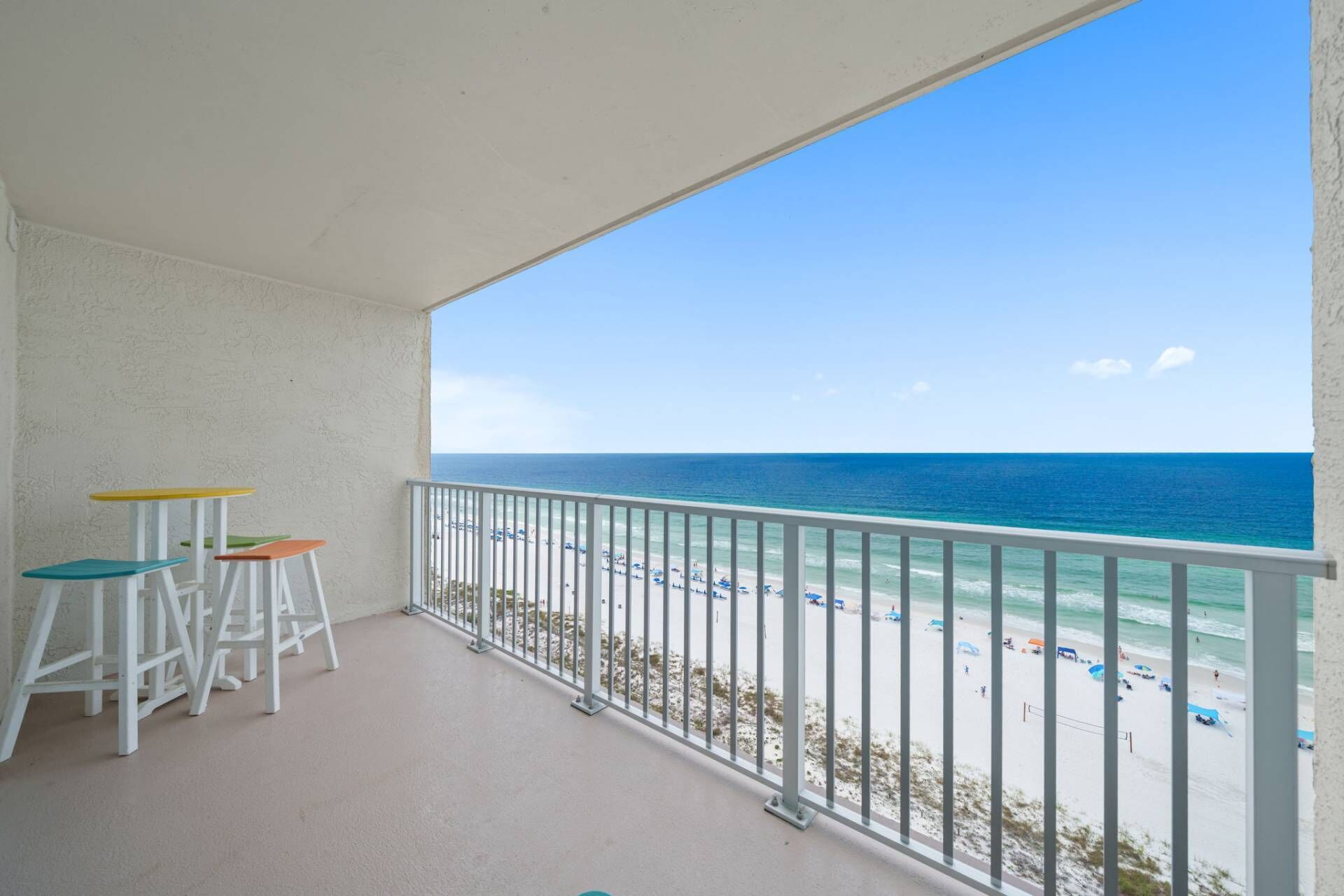 A balcony with a view of the beach and ocean.