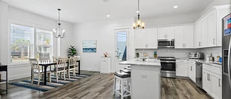 A modern kitchen with white cabinets, stainless steel appliances, and a central island.