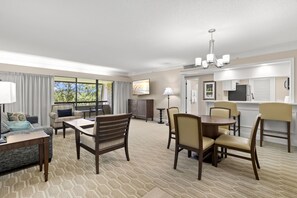 A hotel room with a living area, dining space, and kitchenette.