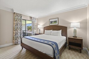 A hotel room with a bed, two bedside lamps, a nightstand, a chair, a window with curtains, and a framed picture on the wall.