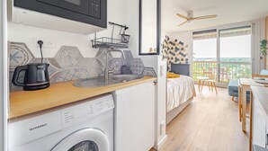 A compact kitchen with a microwave, dishwasher, and a wooden countertop. - Bee Kaz - Beau studio à 30 min du Zoo de Beauval (Montrichard Val de Cher)