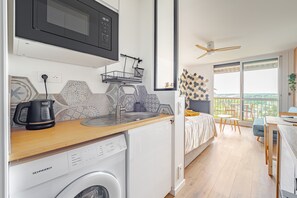 A compact kitchen with a microwave, dishwasher, and a wooden countertop. - Bee Kaz - Beau studio à 30 min du Zoo de Beauval (Montrichard Val de Cher)