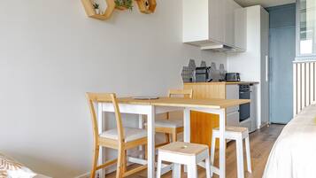 Une cuisine moderne avec des meubles blancs, une table à manger en bois et des chaises.