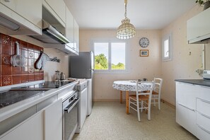 Eine Küche mit Esstisch, Fernseher und Fenster mit Blick.
