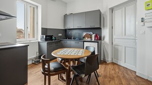 Una cocina compacta con una mesa, sillas y un microondas.