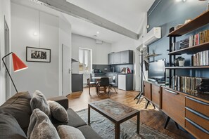 A modern living room with a sofa, a coffee table, and a bookshelf. - Le Cocon de Béziers - Au cœur du centre-ville (Béziers)