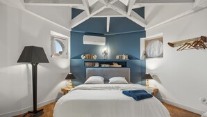 A bedroom with a bed, bedside tables, a lamp, a window, and a wall-mounted drying rack. - Le Dôme - Au cœur du centre-ville de Béziers (Béziers)