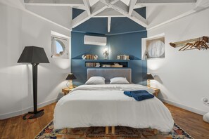 A bedroom with a bed, bedside tables, a lamp, a window, and a wall-mounted drying rack. - Le Dôme - Au cœur du centre-ville de Béziers (Béziers)