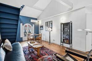 A living room with a sofa, a coffee table, a floor lamp, and a bookshelf. - Le Dôme - Au cœur du centre-ville de Béziers (Béziers)