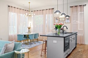 A modern kitchen with a central island, bar stools, a dining table, and pendant lighting. - 6 Min to DT! Luxe Home! Karaoke Stage! (Nashville)