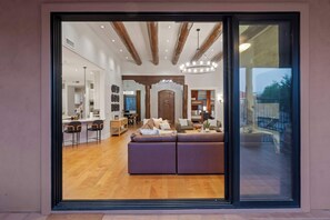 Ein modernes Interieur mit Holzboden, einem großen Sofa und einem Essbereich.