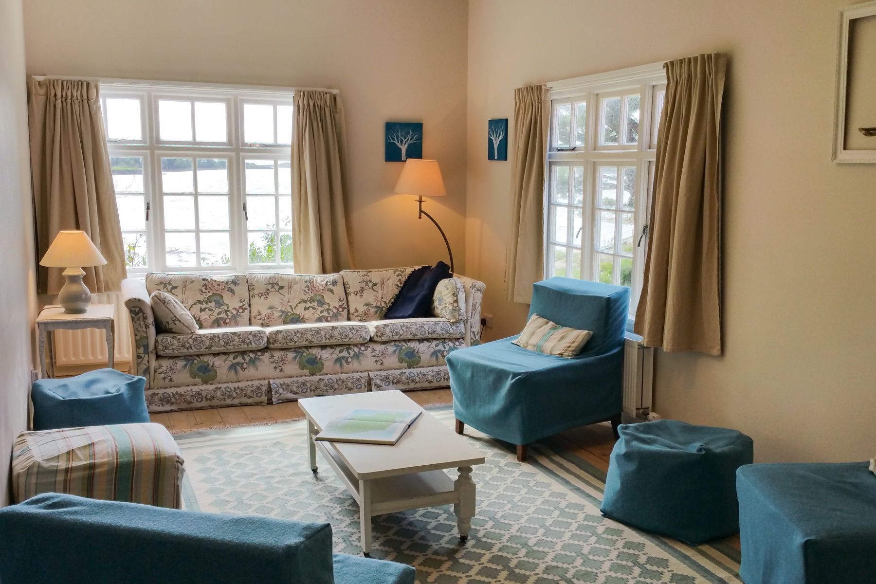 A living room with a sofa, armchair, ottoman, and a small table.