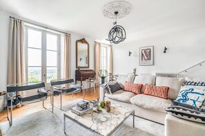 En moderne stue med sofa, sofabord og et klaver.