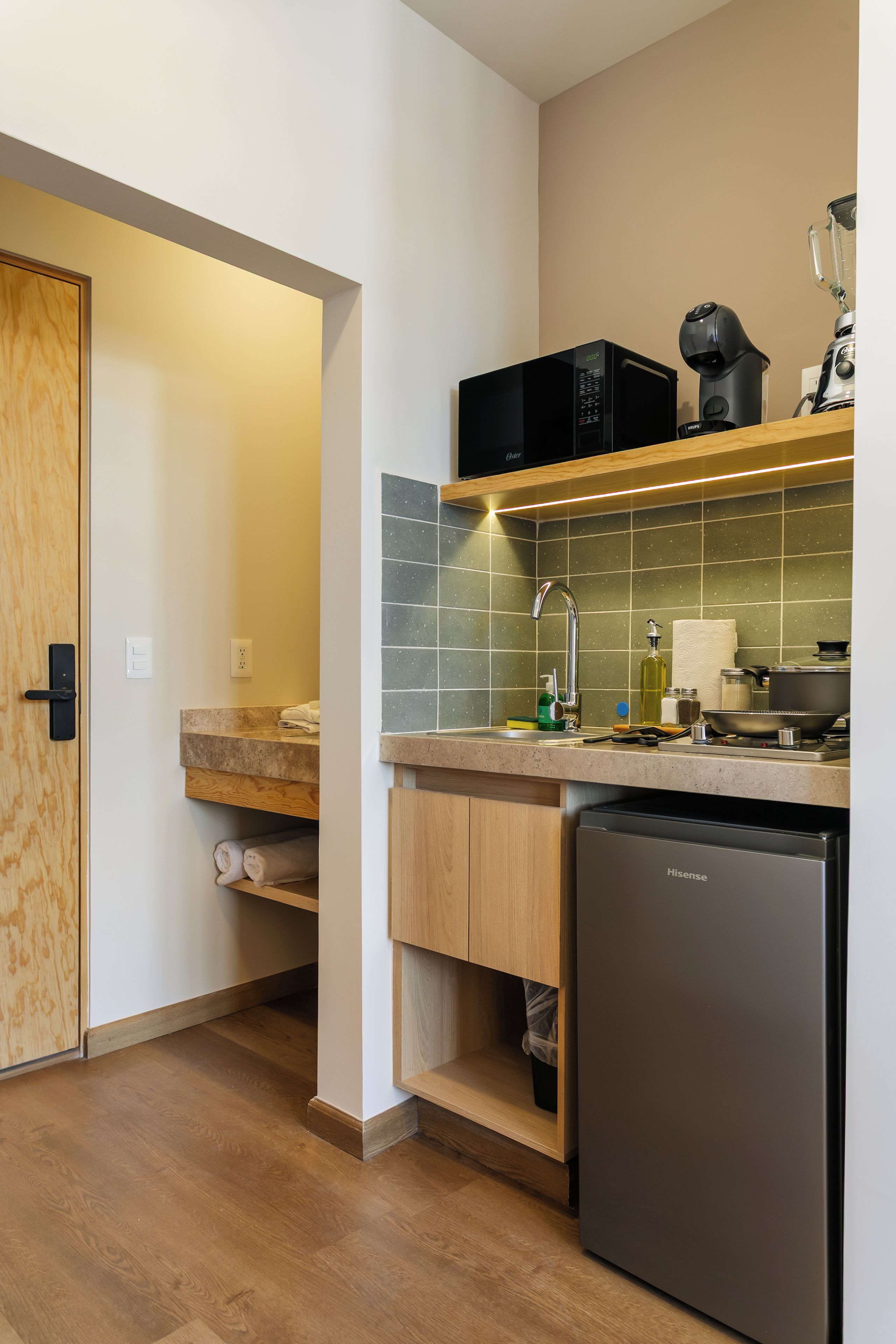 Een moderne keuken met een vaatwasser, een magnetron en een blender op het aanrecht.