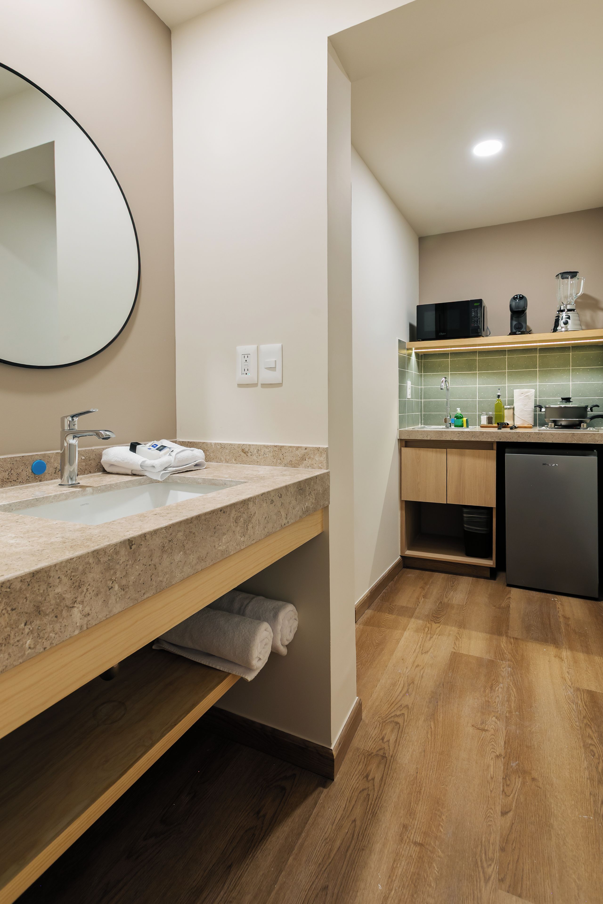 Une salle de bain moderne avec un lavabo, un miroir et un porte-serviettes.