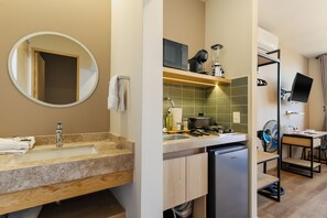 A modern bathroom with a sink, mirror, and a built-in heater. - Madero By Homirent  (Queretaro)