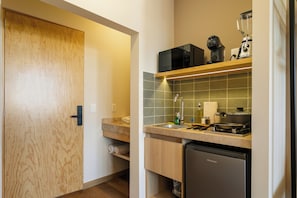 A compact kitchen with a microwave, a coffee maker, and a dishwasher. - Madero By Homirent (Queretaro)