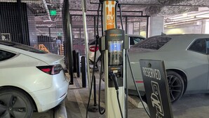 Una estación de carga para coches con un cartel que indica que está reservada para vehículos eléctricos.