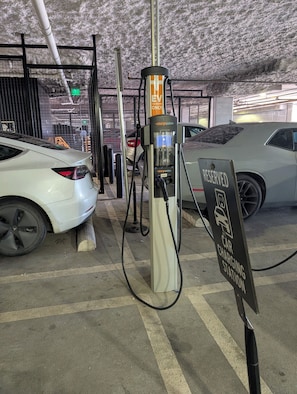 A car charging station with a sign indicating it is reserved for electric vehicles.