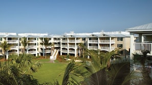 A multi-story hotel with balconies, a central courtyard, and palm trees. - Key West 2BR Retreat – Ocean Views & Island Adventure (Key West)