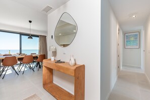 A modern hotel room with a dining area, a large mirror, and a view of the sea. - Bali II | Costa del Sol Penthouse with Amazing Views (Rincón de la Victoria)