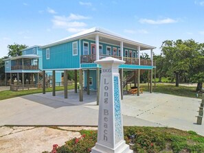A two-story building with a balcony, a covered area, and a sign reading 'Long Beach.' - The Gulf Pearl - Beach House (Long Beach)