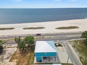 A coastal property with a single-story building, a paved driveway, and a road leading to the beach. - The Gulf Pearl - Beach House (Long Beach)