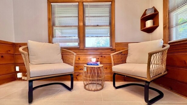 A room with two wicker chairs, a small round table, and a window with blinds. - Stylish 2BR + Office | Near Cleveland Clinic+Shops (South Euclid)