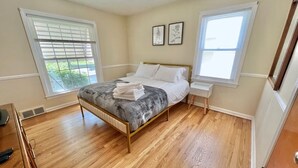 A bedroom with a bed, bedside tables, and a window. - Stylish 2BR + Office | Near Cleveland Clinic+Shops (South Euclid)