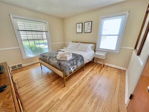 A bedroom with a bed, bedside tables, and a window. - Stylish 2BR + Office | Near Cleveland Clinic+Shops (South Euclid)
