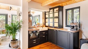 Eine moderne Küche mit dunklen Schränken, einer Holz Arbeitsplatte und einer Kaffeemaschine.