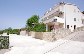 Ein zweistöckiges Haus mit einer Steinmauer und einem Balkon.