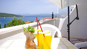 A balcony with a table, a vase, and two drinks. - Gorgeous apartment in Necujam with WiFi (Necujam)