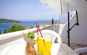 A balcony with a table, a vase, and two drinks. - Gorgeous apartment in Necujam with WiFi (Necujam)