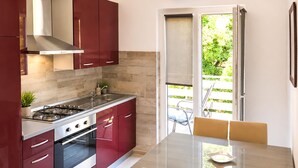 Una cocina moderna con estufa a gas, horno y armarios rojos.