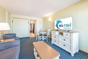 A hotel room with a TV, a dining table, a sofa, a chair, and a dresser. - Nice 1BR Direct Oceanfront at Compass, Heated Pool (Myrtle Beach)