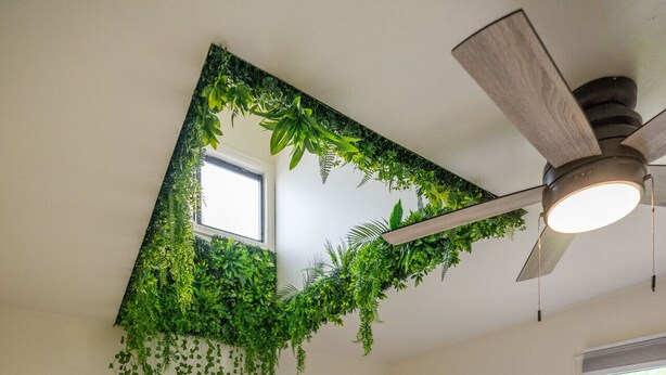 A bedroom with a bed, a ceiling fan, a window, and a wall-mounted plant. - Green Pines | Bunk Room, Air Hockey & Canyons (Cottonwood Heights)