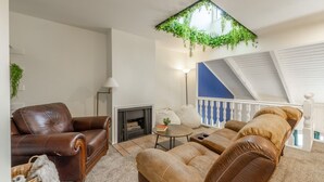 A living room with a fireplace, leather sofas, a coffee table, and a ceiling garden. - Green Pines | Bunk Room, Air Hockey & Canyons (Cottonwood Heights)