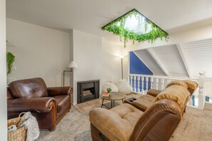 A living room with a fireplace, leather sofas, a coffee table, and a ceiling garden. - Green Pines | Family Ski & Summer Retreat (Cottonwood Heights)