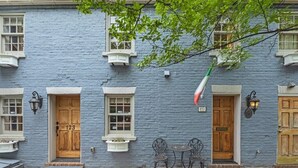 Un bâtiment à la façade bleue, avec des portes numérotées et des places assises à l’extérieur.