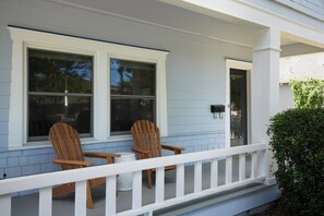 A porch with two wooden chairs and a small table, a white railing, and a door with a mailbox. - Blue Gables 1920s Craftsman Near WWU 4BR 3BA Sleeps 9 Fenced Yard (College Place)
