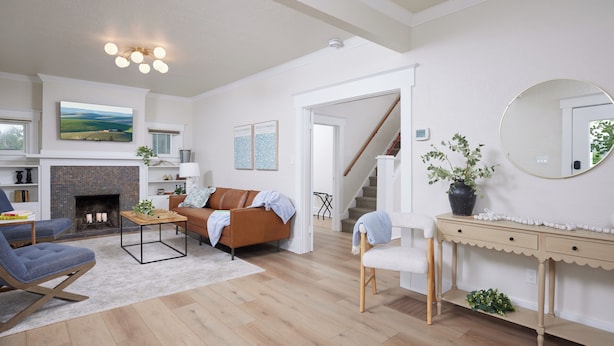 Ein Wohnzimmer mit Kamin, einer Couch, einem Couchtisch und einem an der Wand befestigten Fernseher.