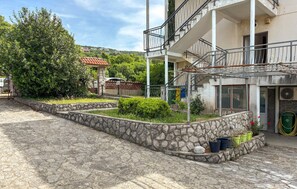 Ein Innenhof mit Steinwegen, ein Gebäude mit einem Balkon und Blick auf die Umgebung.