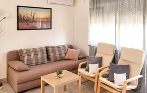 A living room with a sofa, two armchairs, a coffee table, and a painting on the wall. - Beautiful apartment in Krk with WiFi (Krk)