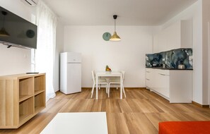 A compact living space with a kitchenette, a dining area, and a TV mounted on the wall. - Lovely apartment in Krk with WiFi (Krk)