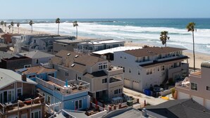 A coastal residential area with beachfront properties, including houses with balconies and a beach in the background. - The Tidal Retreat- Ocean Views (San Diego)