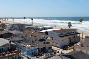 A coastal residential area with beachfront properties, including houses with balconies and a beach in the background. - The Tidal Retreat- Ocean Views (San Diego)