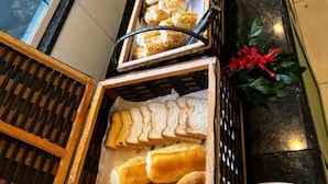 Un bufé con diferentes opciones de comida, incluyendo panadería y pasteles.