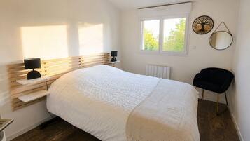 Une chambre à coucher comprenant un lit, des tables de chevet, une chaise, une fenêtre et des éléments de décoration murale.